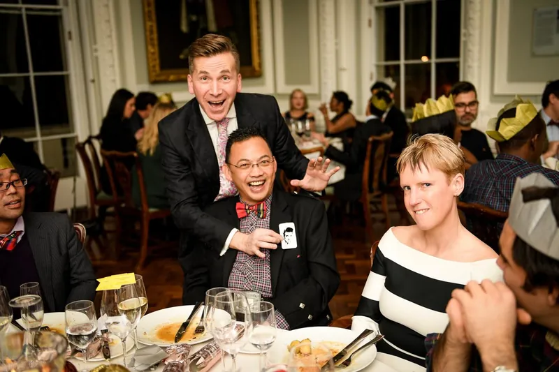 Guests laughing with Martin Sanderson during a corporate dinner