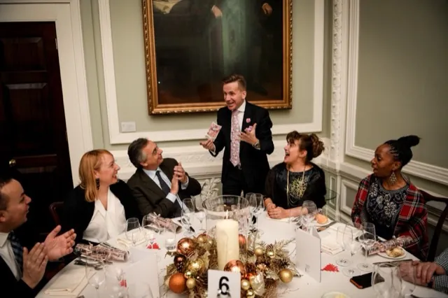 Guests reacting to Martin Sanderson’s close-up magic at a party