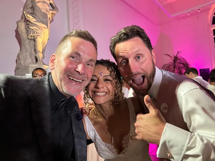 Martin Sanderson taking a selfie with a bride and groom on their wedding day