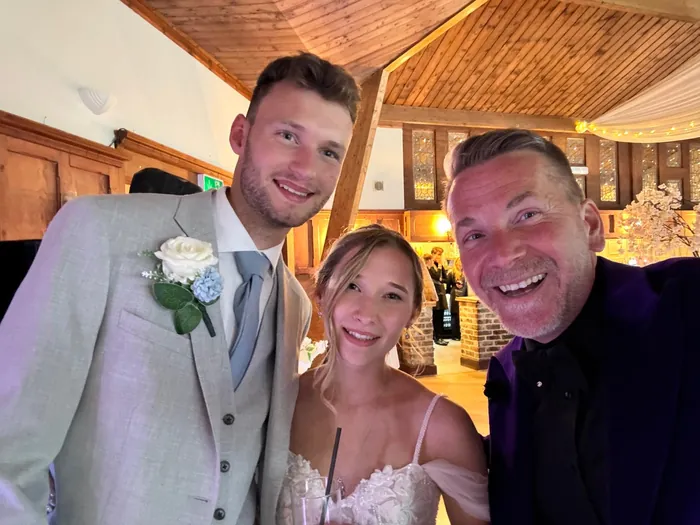 Bride and groom smiling for a selfie with their wedding magician