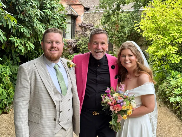 Martin Sanderson with a couple in the garden after their wedding ceremony