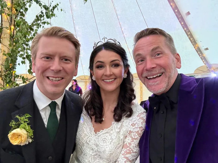 A bride and groom laughing in a selfie with Martin Sanderson